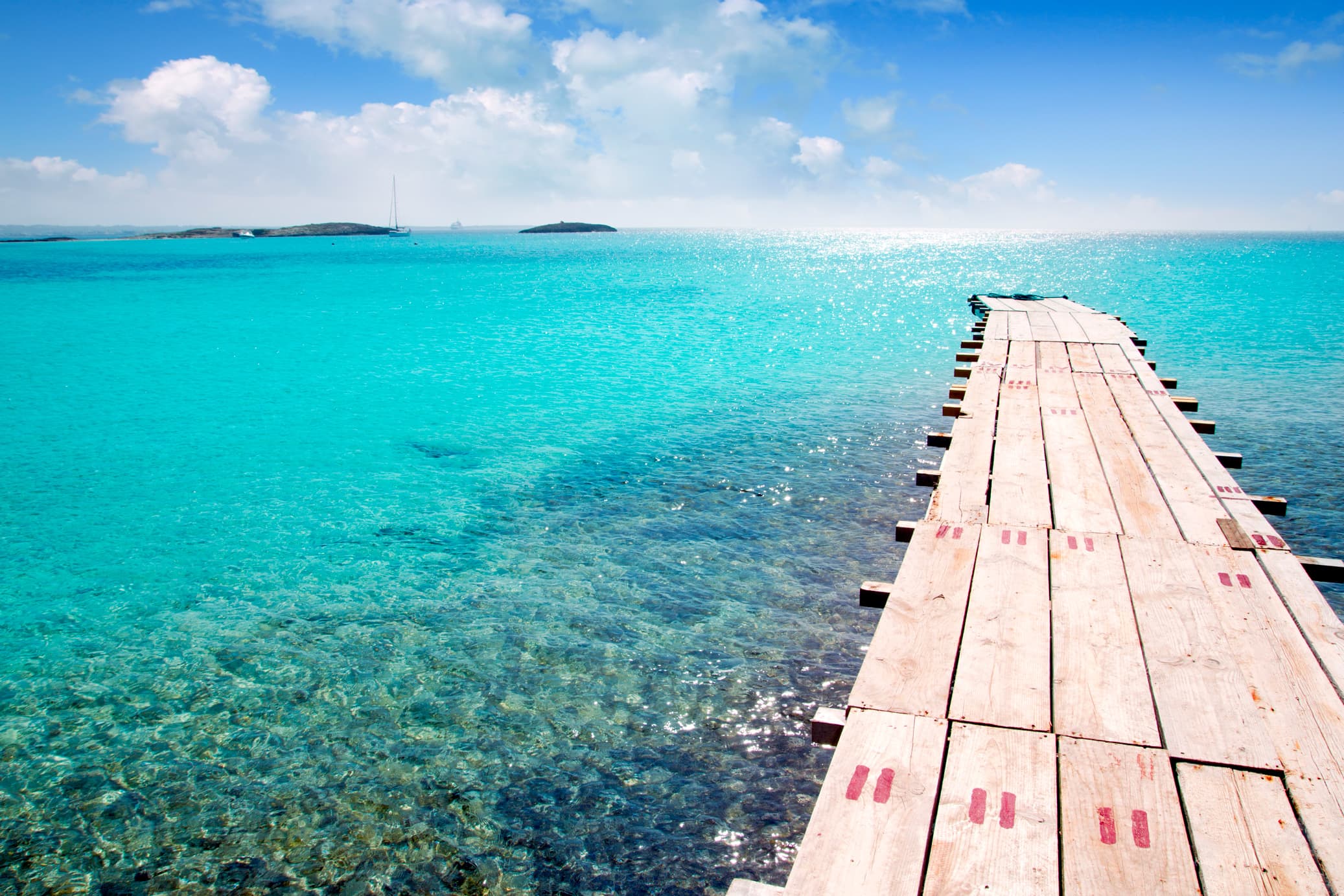Pantalán de madera sobre aguas turquesa cristalina en Formentera